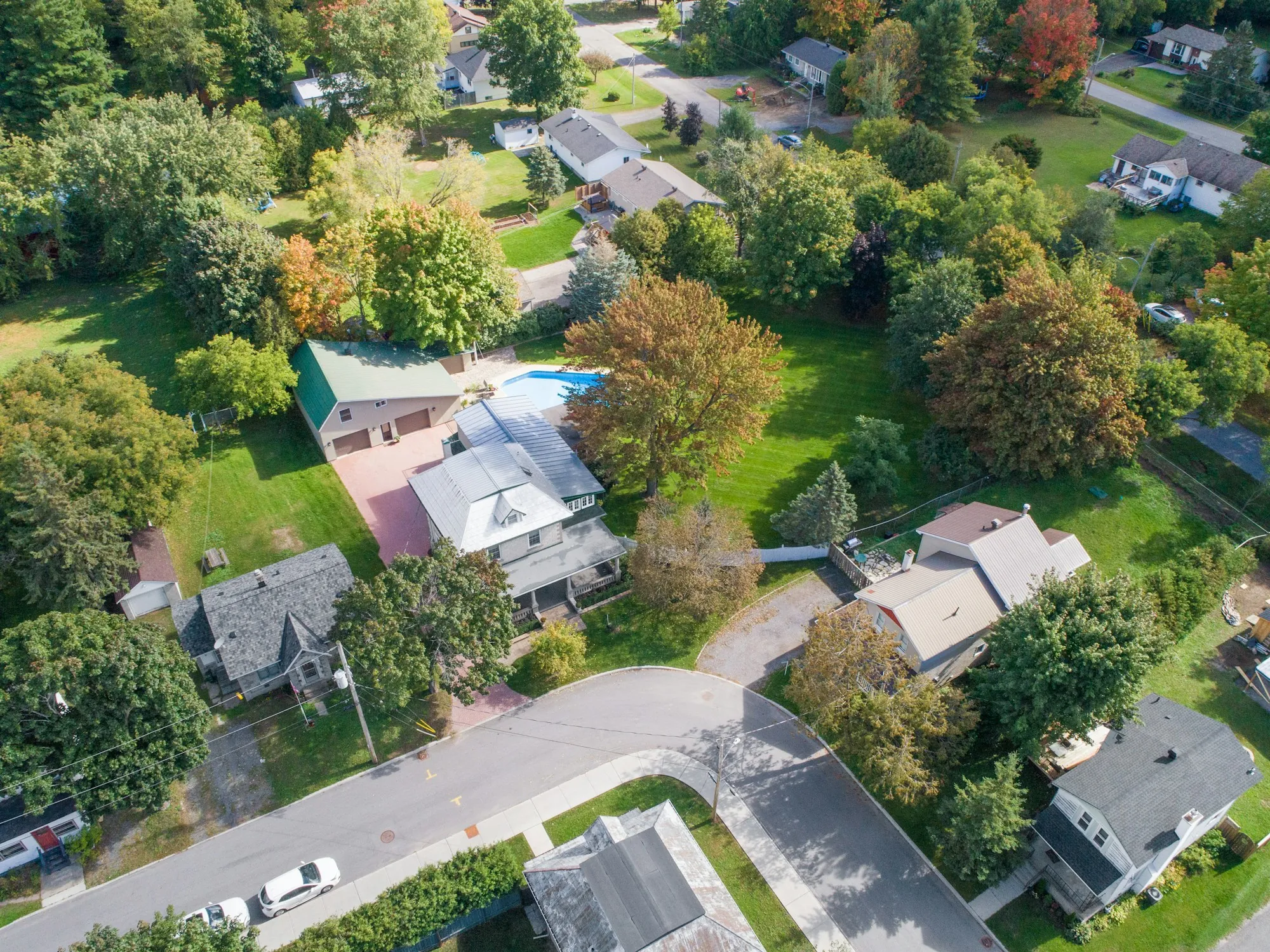 Aerial view of houses with green yards and mature trees