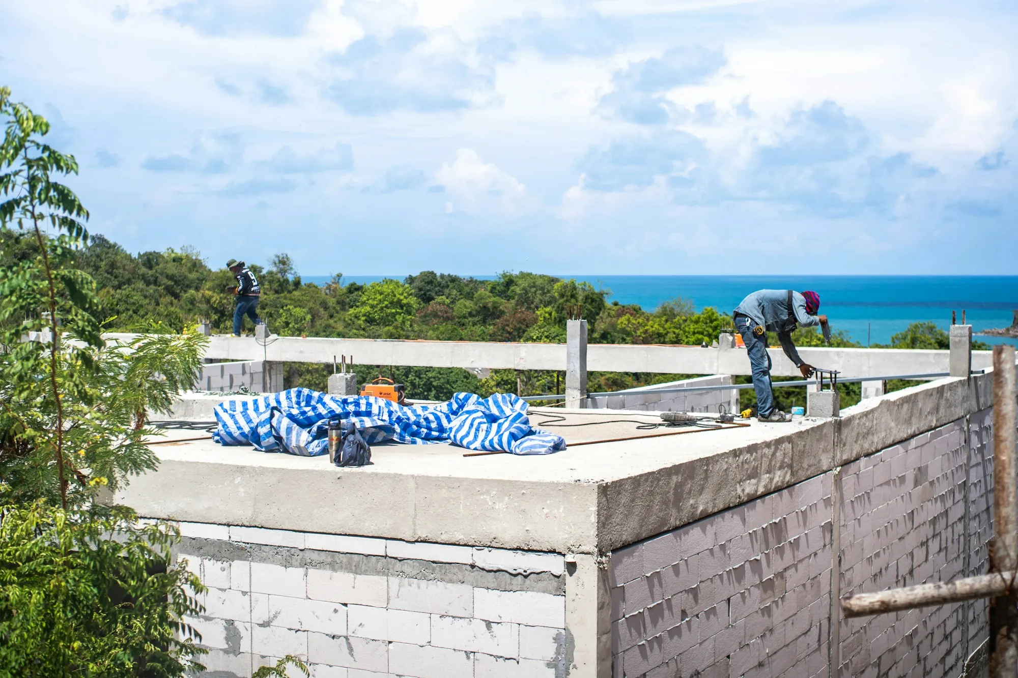 Worker on the flat roof of a block building near the coast