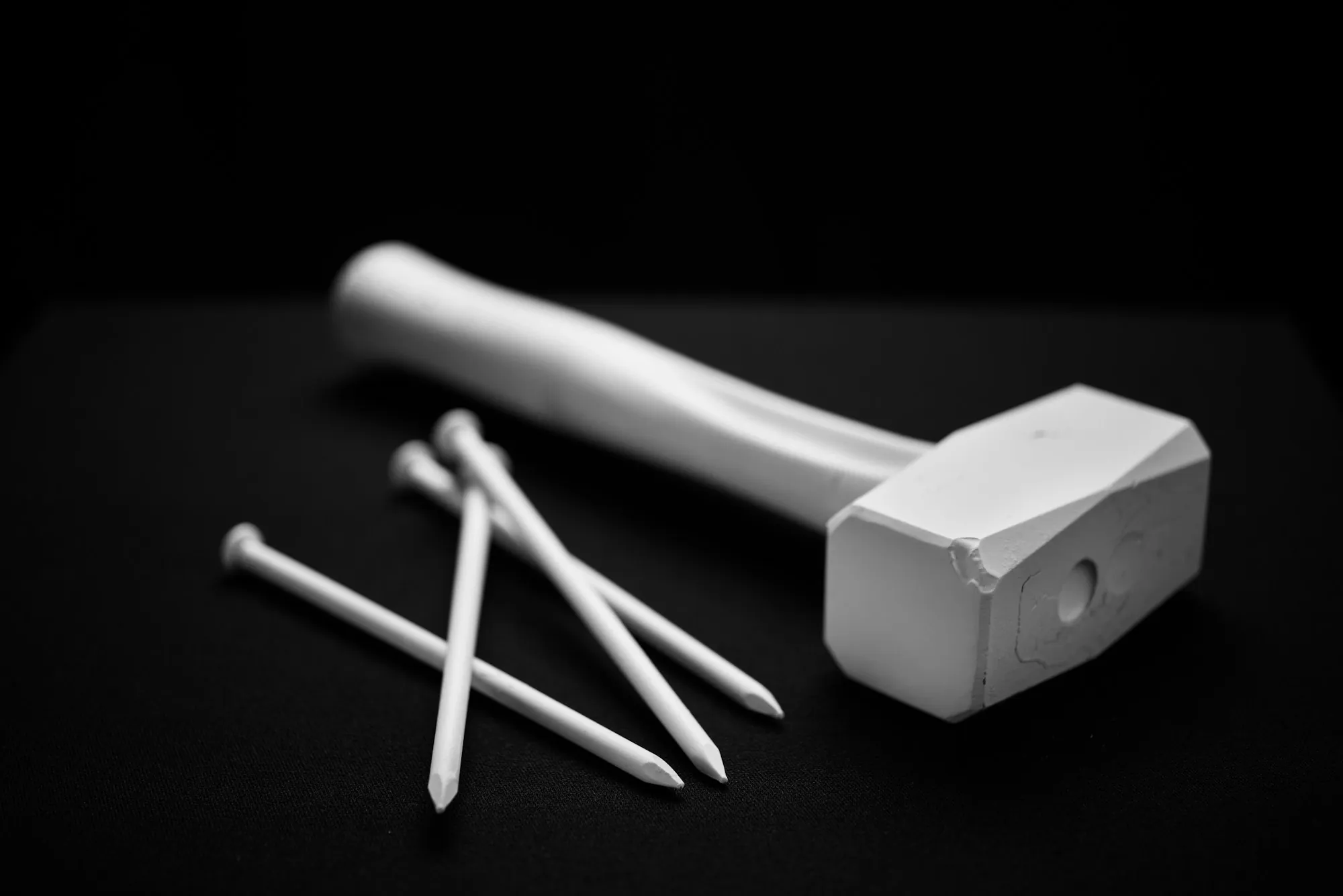 Hammer and nails arranged on a black background